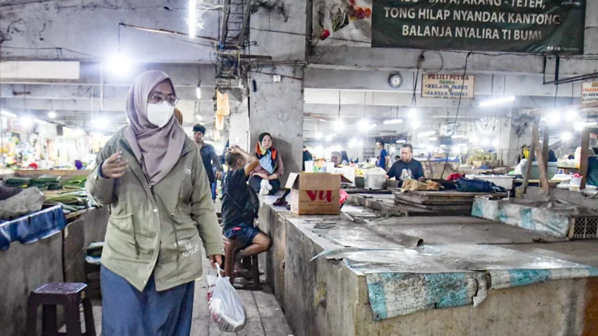 Warga berjalan membawa belanjaan menggunakan kantong plastik di dekat poster imbauan kurangi penggunaan plastik di Pasar Kosambi, Jalan Ahmad Yani, Kota Bandung, Jumat (11/7). Foto: Dimas Rachmatsyah / Jabar Ekspres