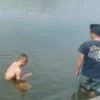Petugas Dinas Pemadam Kebakaran (Disdamkar) Kabupaten Bandung membantu evakuasi sebuah handphone milik warga yang tercebur ke kolam di kawasan Podomoro, Baleendah, Kabupaten Bandung, Selasa (15/7). Foto Istimewa
