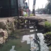 Seorang anak sedang menyebrangi jembatan darutat dari kayu hasil swadaya warga yang kondisinya kian rapuh, sebab mangkraknya proyek normalisasi drainase DPUTR Kabupaten Bandung di Jalan Raya Rancaekek-Majalaya, wilayah Kampung Rancabatok, RW09 dan RW22, Desa Rancaekekwetan, Kecamatan Rancaekek. (Yanuar/Jabar Ekspres)