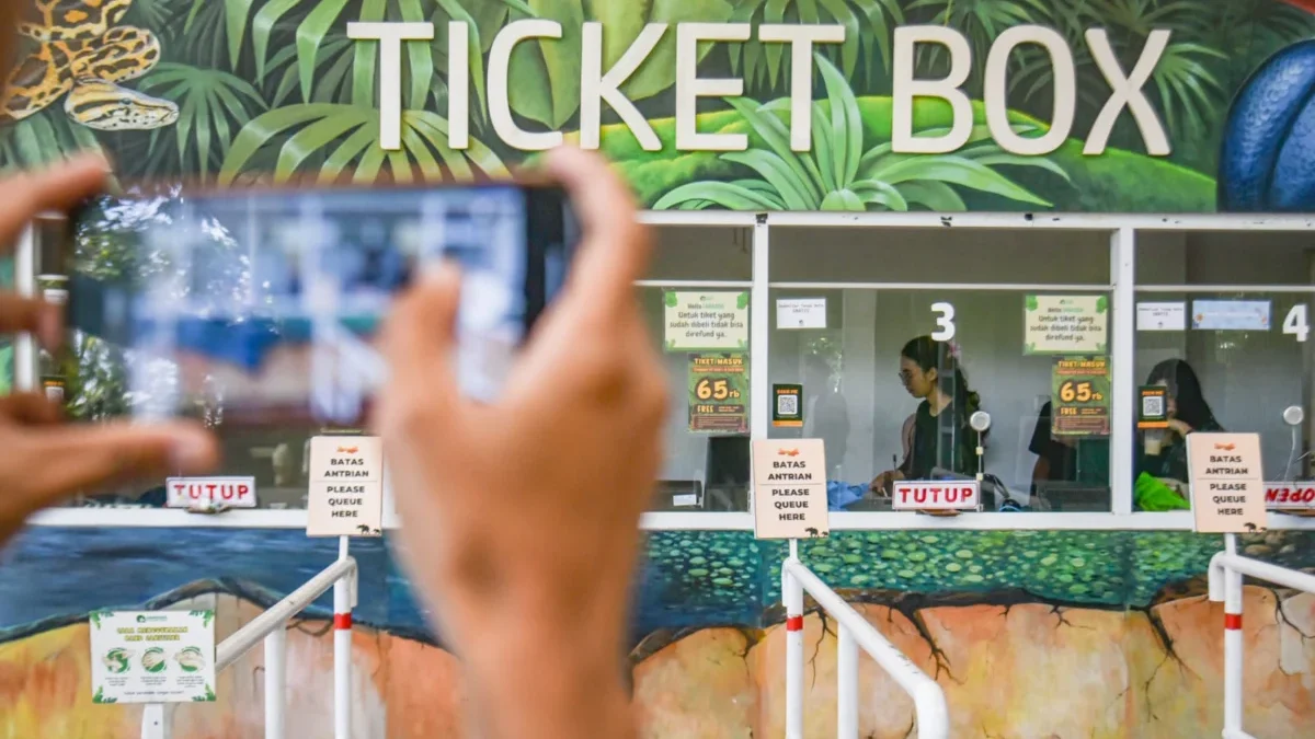 Bandung Zoo Ditutup Sementara! Konflik Dualisme Pengelola Picu Ketegangan Petugas berjaga di dalam loket pembelian tiket yang ditutup di Kebun Binatang Bandung, Jalan Tamansari, Kamis (3/7). Manajemen Bandung Zoo menutup operasional kebun binatang untuk sementara waktu, akibat adanya dualisme kepengelolaan. Foto: Dimas Rachmatsyah / Jabar Ekspres