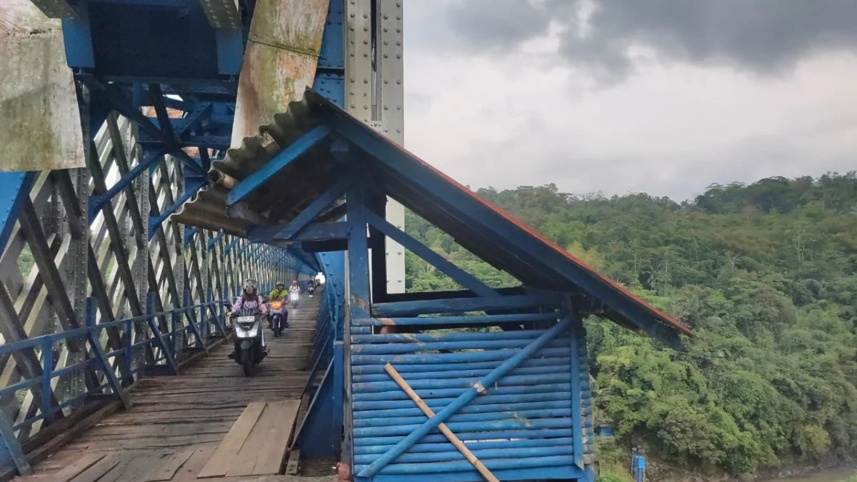 Pengendara sepeda motor melinta di Jembatan Cirahong, Selasa (8/7/2025). Tahun 2026, Jembatan Cirahong 2 akan dibangun untuk memaksimalkan akses penghubung Tasikmalaya dan Ciamis. (Cecep Herdi/Jabar Ekspres)