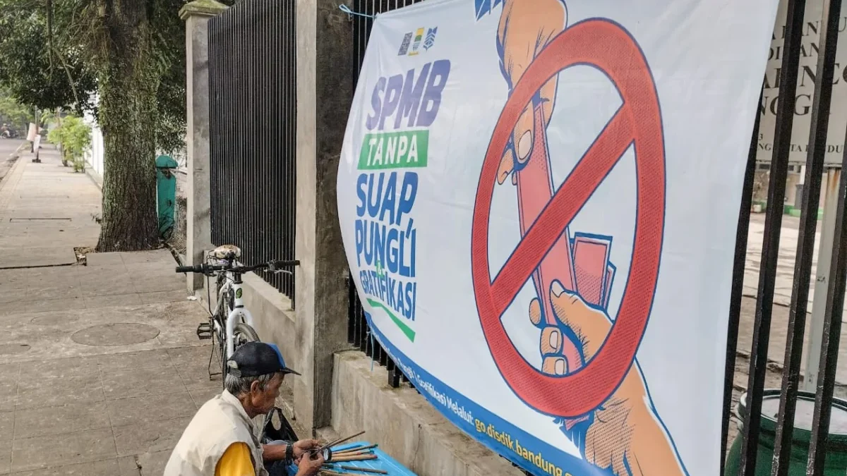 Ilustrasi: Seorang warga berada di depan spanduk SPMB. Foto: Dimas Rachmatsyah / Jabar Ekspres