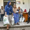 Warga membawa beras saat pendistribusian bantuan cadangan pangan di Kelurahan Cihapit, Kota Bandung, Jumat (18/7). Menurut data Pemerintah Kota Bandung menyalurkan bantuan cadangan pangan dari Badan Pangan Nasional (Bapanas) berupa 10 kilogram beras kepada 85.167 warga di 151 yang ada kelurahan di Kota Bandung. Foto: Dimas Rachmatsyah / Jabar Ekspres