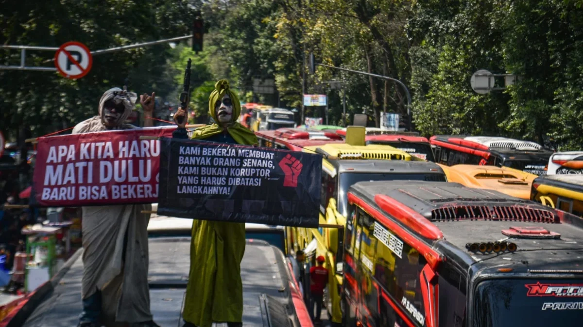 Massa yang tergabung dalam Forum Solidaritas Para Pekerja Pariwisata Jawa Barat (P3JB) membawa spanduk dan men