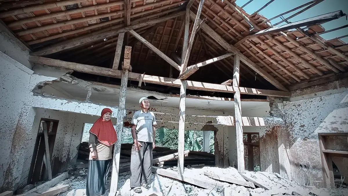 Di Antara Puing dan Janji, Hilman dan Istrinya Pilih Bertahan di Tengah Bahaya Di tengah ketidakpastian relokasi, sepasang lansia penyintas longsor ini memilih tetap tinggal di rumah sederh