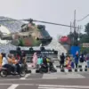 Masyarakat yang memarkirkan kendaraannya di jalan saat sedang berfoto di Tugu Helikopter Simpang Empat Kandang
