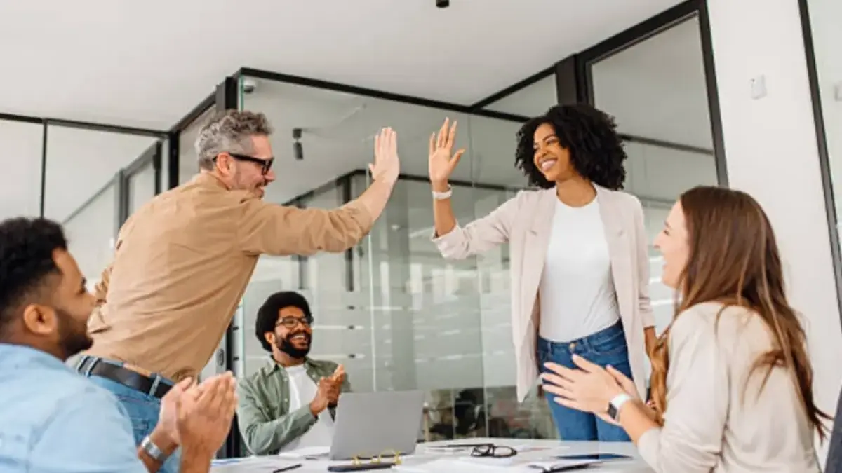 25 Ucapan Awal Bulan Agustus 2025 yang Bisa Pacu Semangatmu, Cocok jadi Status Medsos dan WA Tim kantor merayakan kesuksesan dengan high-five.