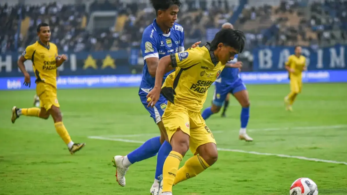 Penggawa Persib Bandung Kakang Rudianto berebut bola dengan penggawa Semen Padang FC Ripal Wahyudi pada pertan
