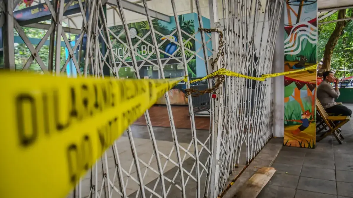 Kisruh Manajemen Kebun Binatang Bandung, Satwa Tetap Terurus Petugas kepolisian berjaga di samping garis polisi yang terpasang di gerbang masuk Kebun Bintang Bandung yang