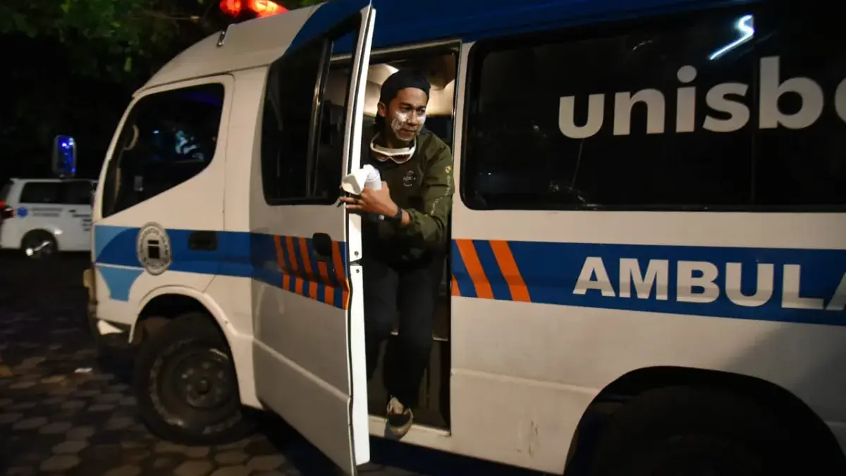 Petugas kesehatan keluar dari mobil ambulans di kampus Universitas Islam Bandung, Jalan Tamansari, belum lama