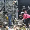 Massa yang tergabung dalam Masyarakat Kampung Kota Bandung melempar sampah saat aksi unjuk rasa di depan gedu
