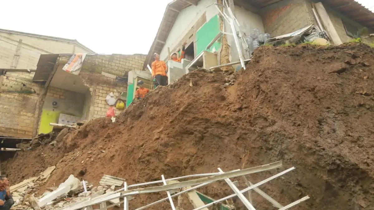 Petugas BPBD Kota Bogor bersama warga membersihkan material akibat bencana longsor di Kampung Sawah, Kelurahan