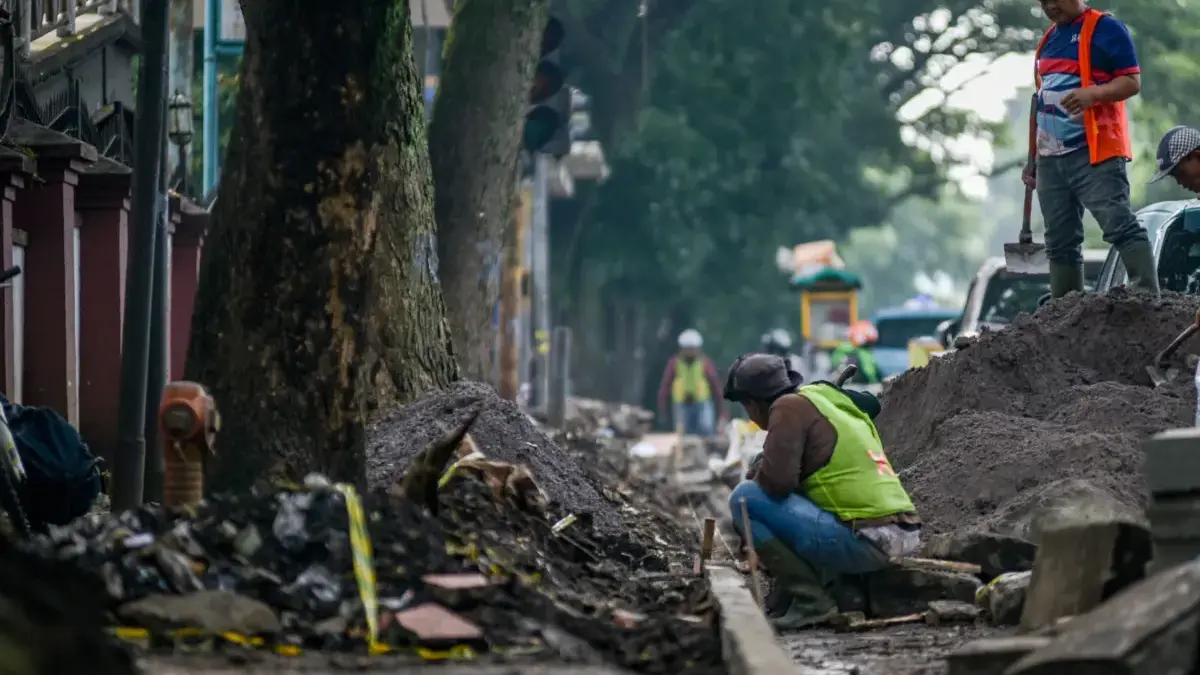 Pekerja menyelesaikan perbaikan trotoar di Jalan Pajajaran, Kota Bandung, Jumat (19/9). Foto: Dimas Rachmatsya