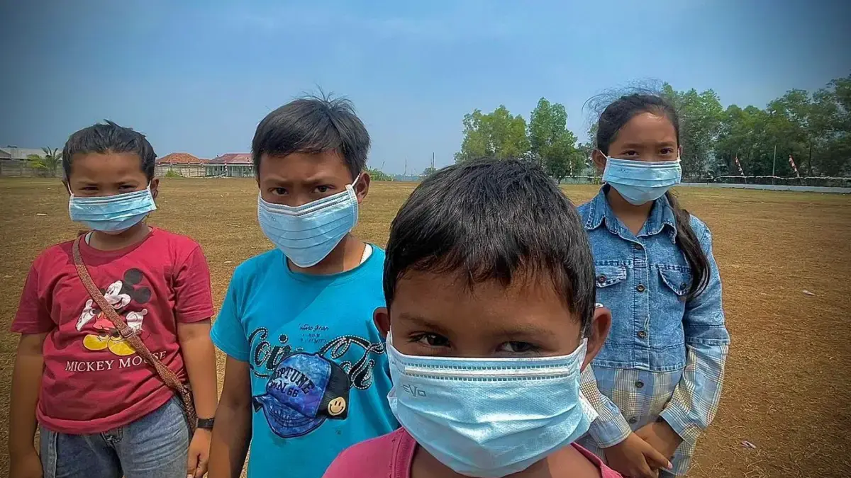 Sejumlah anak-anak tampak mengenakan masker untuk melindungi diri dari paparan asap akibat bencana kebakaran.