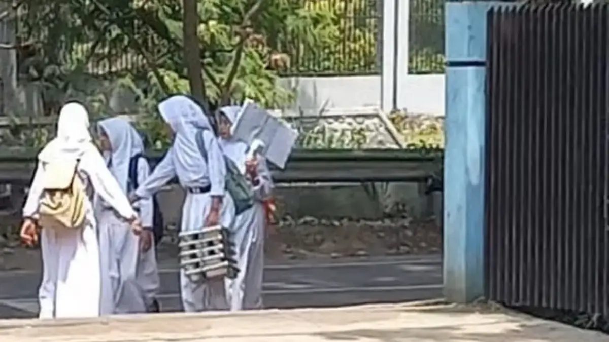 Beberapa siswa SDN 216 Sondariah, Kel. Rancapanumpang, Kec. Gedebage terlihat berjalan kaki dengan membawa wad