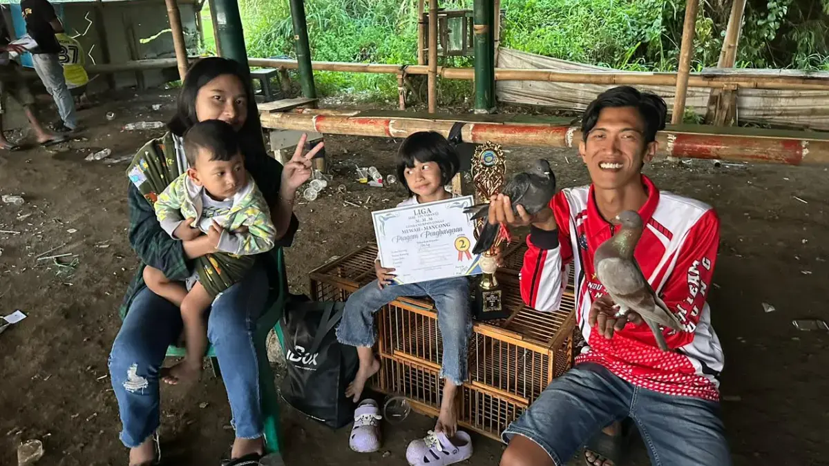 Sukma Pandu Permana bersama istri dan anak-anaknya berpose usai meraih juara dalam lomba merpati