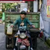 Petugas Kang Pisman menggunakan sepeda motor mengambil sampah di perumahan di Kota Bandung. Foto: Dimas Rachma