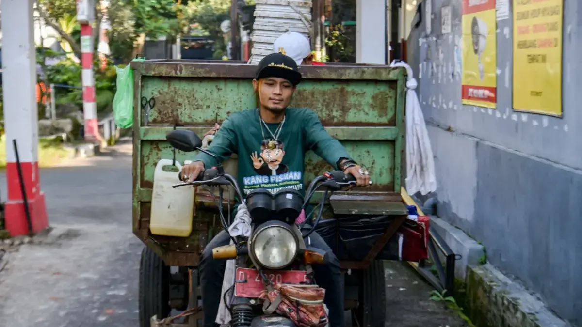Petugas Kang Pisman menggunakan sepeda motor mengambil sampah di perumahan di Kota Bandung. Foto: Dimas Rachma