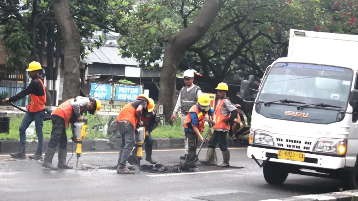 PERBAIKI JALAN: Sejumlah petugas saat memperbaiki jalan yang rusak di Kota Bandung. Pembangunan infrastruktur