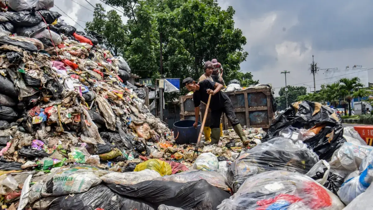 DLH Kota Bandung Sebut Perubahan Ritase ke Tonase Sebabkan Penumpukan Sampah Petugas memilah sampah yang meluber hingga ke jalan di TPS Budhi Jalan Amir Mahmud, Kelurahan Sukaraja