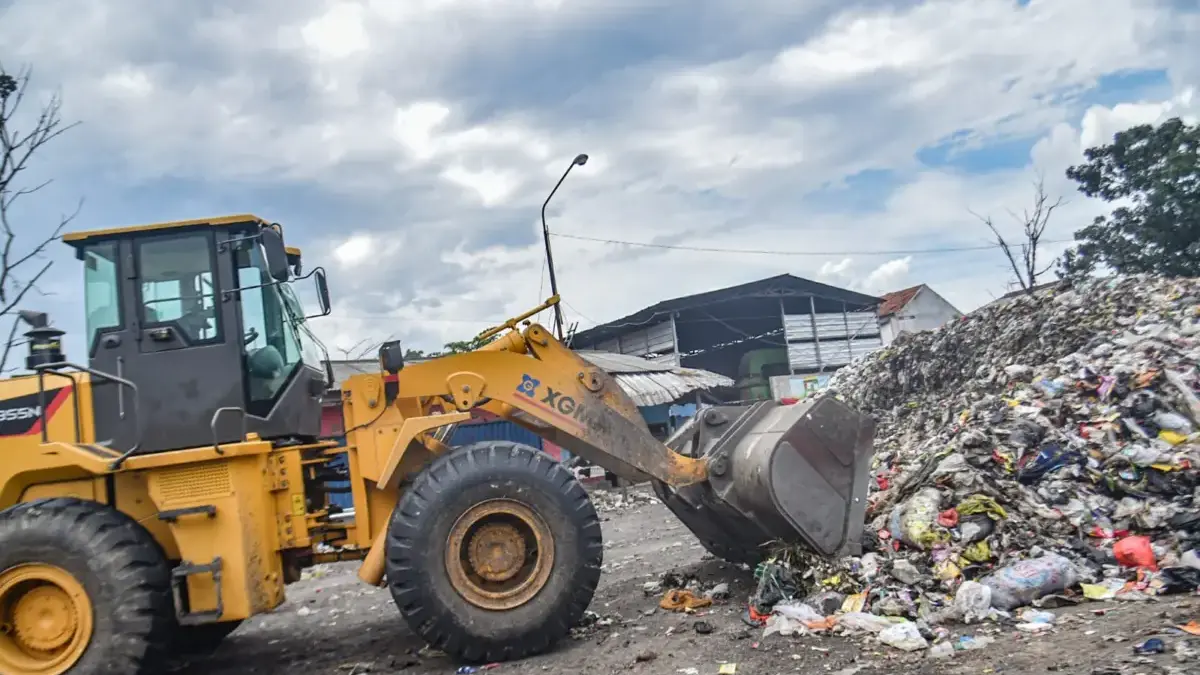 Sampah Menumpuk di Selokan, DLH Cimahi Akui Sosialisasi Belum Optimal Operator mengoperasikan alat berat untuk mengangkut sampah di tumpukan sampah di TPS Pasar Ciwastra, Kota Ban