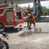 Petugas Damkar KBB saat mematikan api yang membakar sebuah motor di SPBU Cihampelas