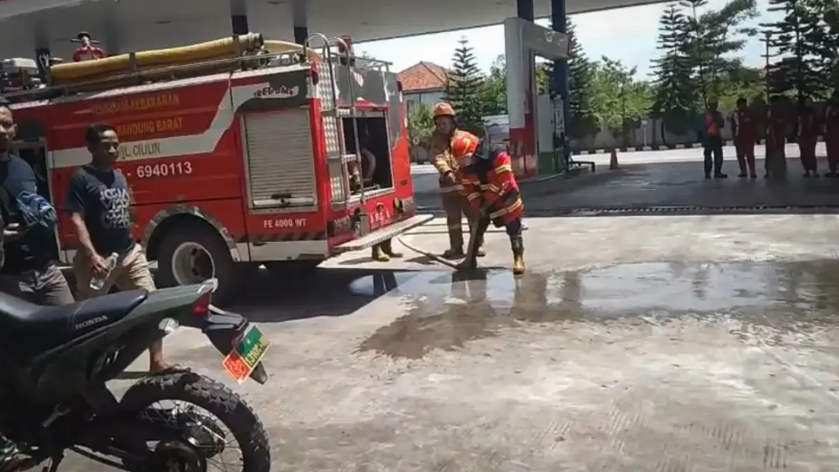 Petugas Damkar KBB saat mematikan api yang membakar sebuah motor di SPBU Cihampelas