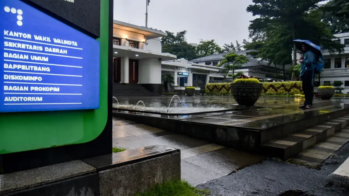 Seorang jurnalis berjalan melintasi gedung pemerintahan Balai Kota Bandung, Jalan Wastukencana, Kota Bandung,