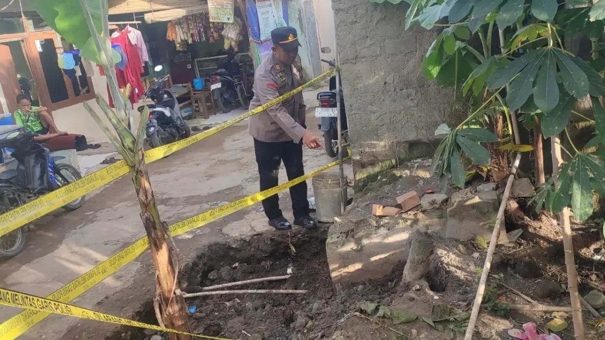 Polisi memasang garis police line di lokasi penemuan benda mencurigakan yang diduga mortir di Blok Sukamaju, D