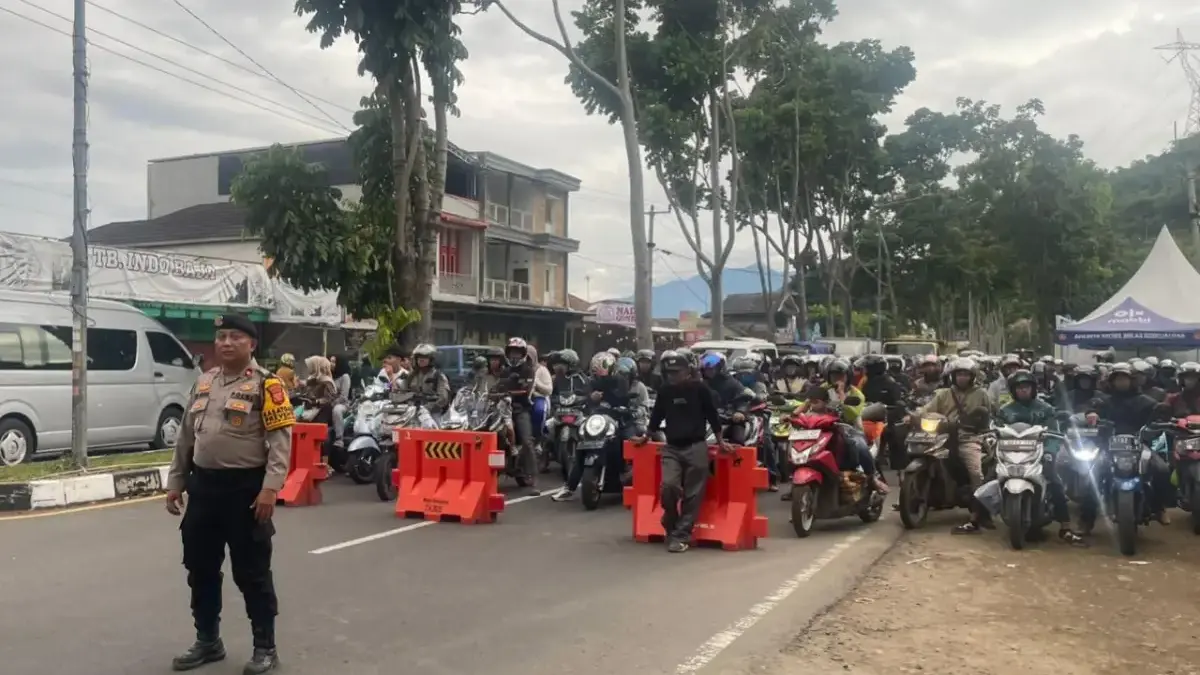 Petugas kepolisian saat memberlakukan one way di pertigaan Sadu, Kecamatan Soreang, Kabupaten Bandung, Sabtu