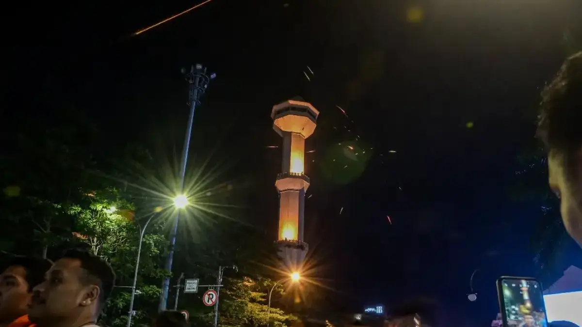 Warga menyaksikan atraksi kembang api saat malam pergantian tahun di Bandung. Foto: Dimas Rachmatsyah
