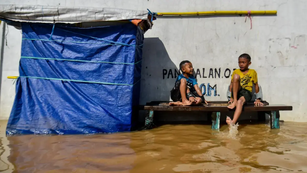 Ilustrasi: Dua anak duduk di pangkalan ojek yang terendam banjir di Baleendah, Kabupaten Bandung, beberapa wak