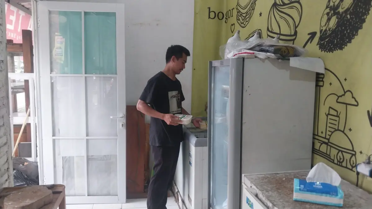 Irwan (26) saat merapihkan barang dagangannya di wilayah Yasmin, Kota Bogor. Foto: Regi Pratasyah Vasudewa