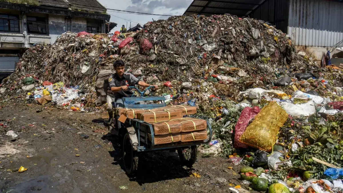Pengemudi membawa barang menggunakan becak motor di Tempat Penampungan Sementara (TPS) Pasar Induk Caringin, K