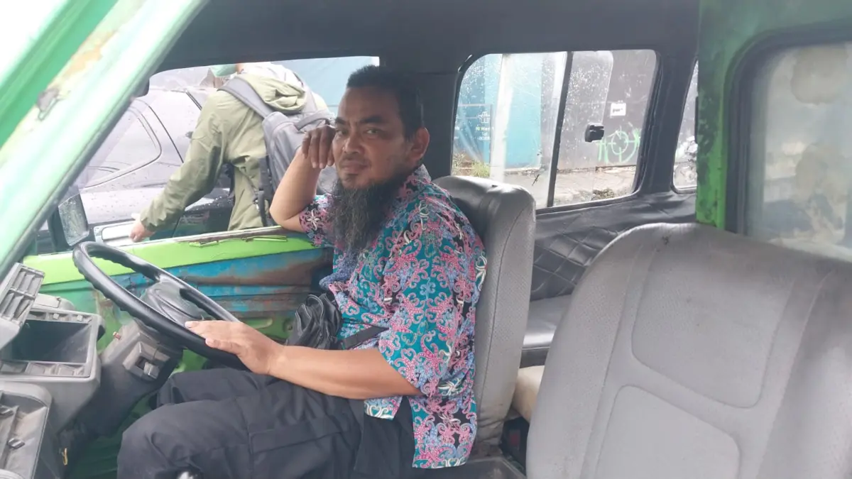 Sopir Angkot di Kota Bogor Sutanda (47) saat menunggu penumpang di Jalan Mayor Oking. Foto: Regi