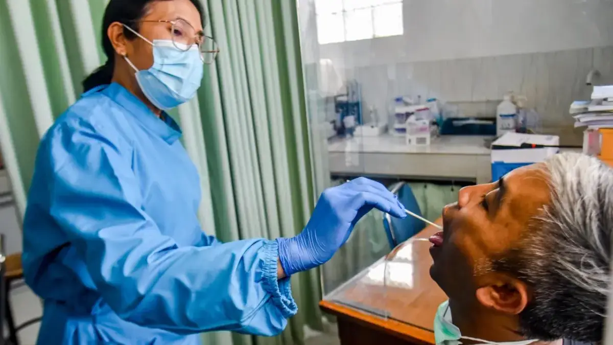 Petugas mengambil sampel dahak seorang pasien saat pemeriksaan deteksi dini superflu di Puskesmas Padasuka, Ko