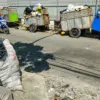 Pengendara melintas disamping gerobak sampah yang berisi penuh sampah di Tempat penampungan sementara (TPS)