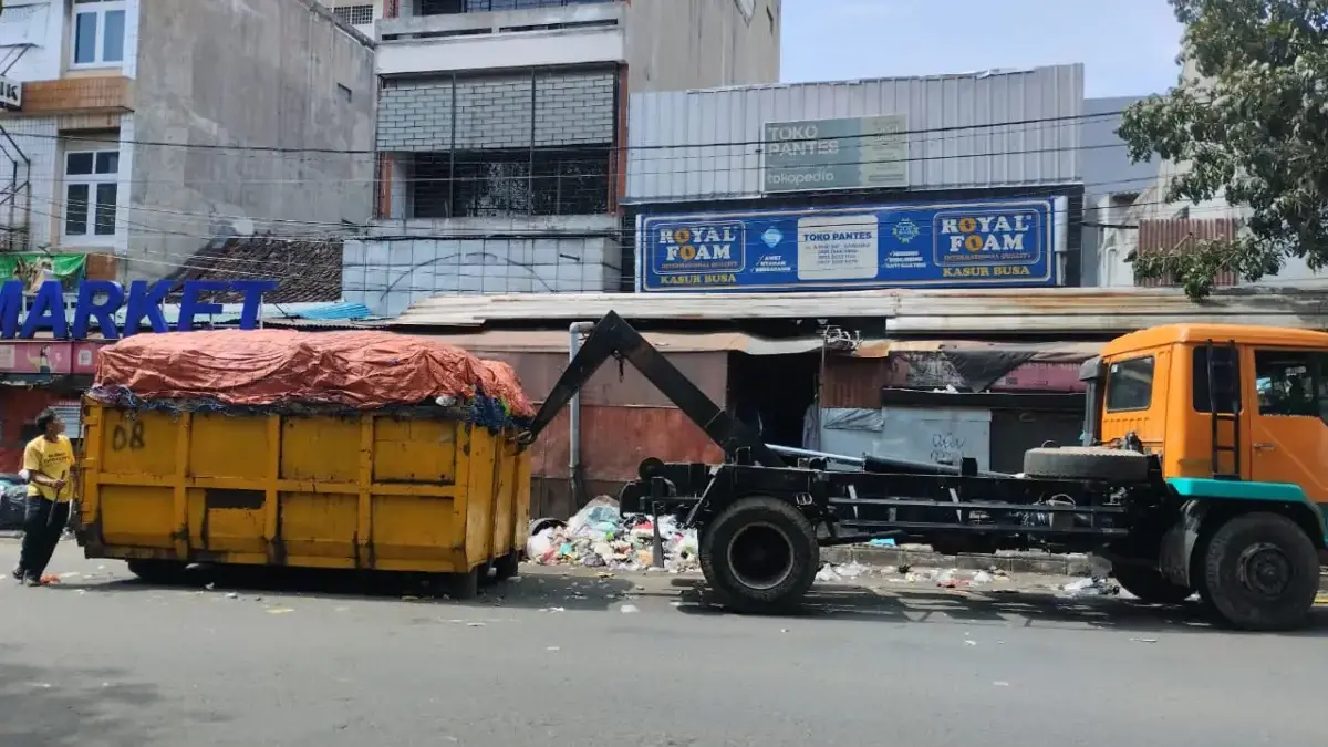 Petugas mengangkut sampah menggunakan truk di Jalan Ahmad Yani, Cicadas, Kota Bandung. Foto: Dimas Rachmatsyah