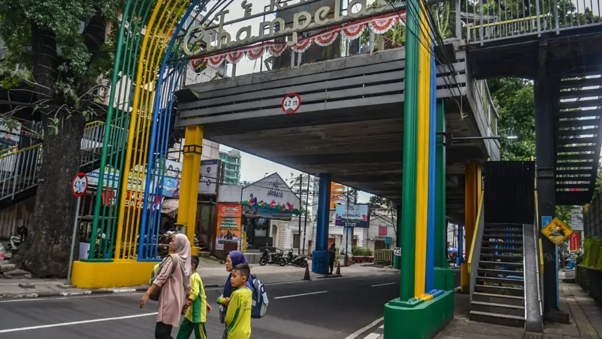 Warga menyeberang jalan di depan Jembatan Teras Cihampelas di Kota Bandung, Rabu (14/1)