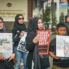 Warga yang tergabung dalam Forum Dago Melawan membawa poster saat mendatangi Kantor Agraria dan Pertanahan