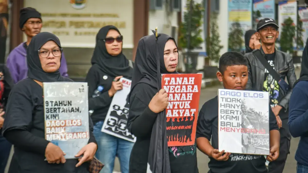 Warga yang tergabung dalam Forum Dago Melawan membawa poster saat mendatangi Kantor Agraria dan Pertanahan