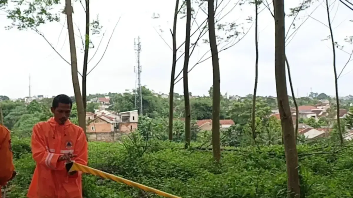 Petugas BPBD Kabupaten Bogor saat memasang police line di Tanah Eks TPA Hutan Kota Pondok Rajeg setelah longso