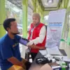 Petugas medis AdMedika dan TelkoMedika melakukan pemeriksaan tekanan darah kepada warga terdampak banjir dan t