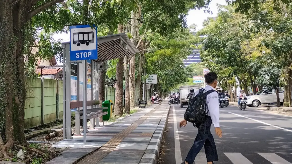 Pelajar menyeberang jalan di depan Halte Feeder Metro Jabar Trans di Jalan Turangga, Kota Bandung