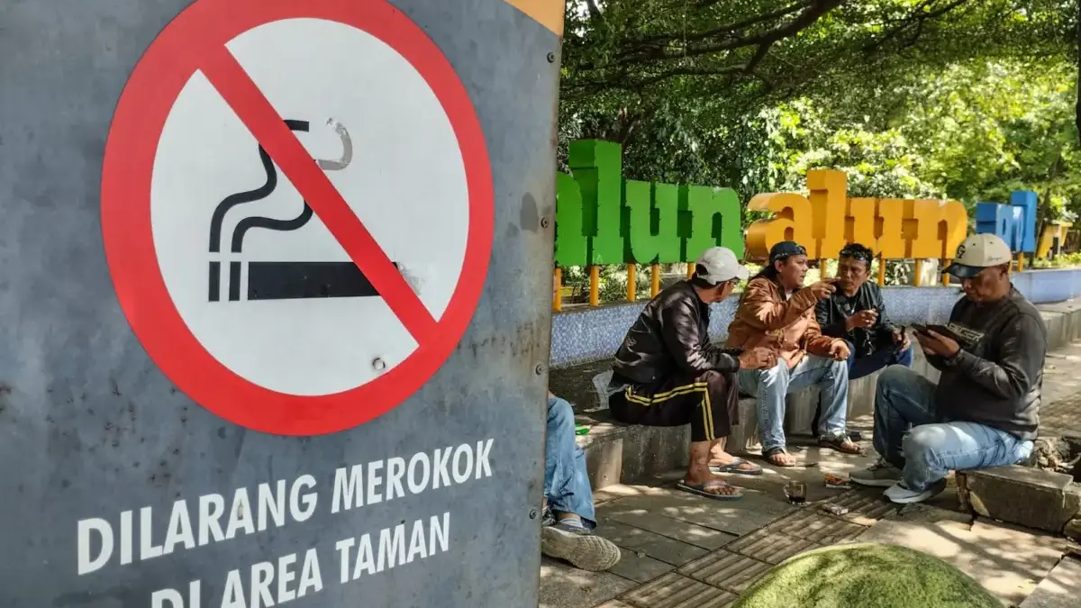 Asap Rokok Masih Mengintai Publik Bandung, KTR Dinilai Belum Maksimal Warga duduk di kawasan tanpa rokok di Taman Alun Alun Regol, Kota Bandung, Senin (2/2)