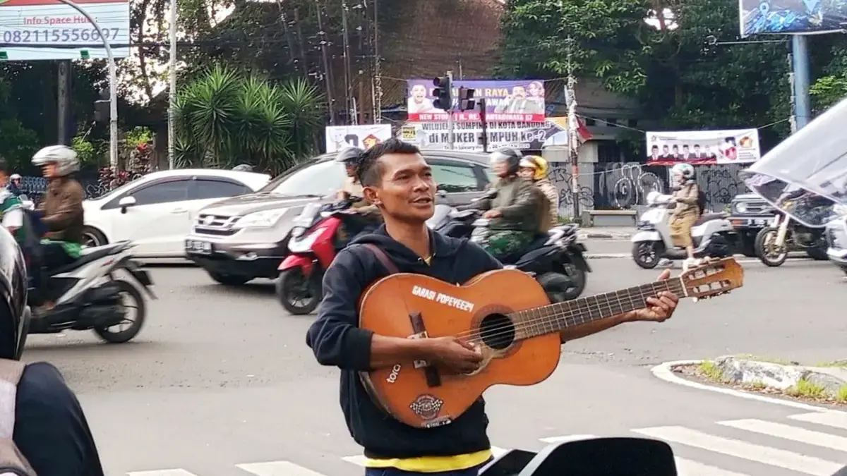 Pengamen menggunakan gitar di Jalan Pasti Kota Bandung