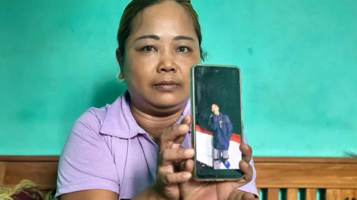 Eti Rohaeti (39 tahun) menunjukkan doto anaknya seorang ABK yang hilang di Selat Bali November 2025