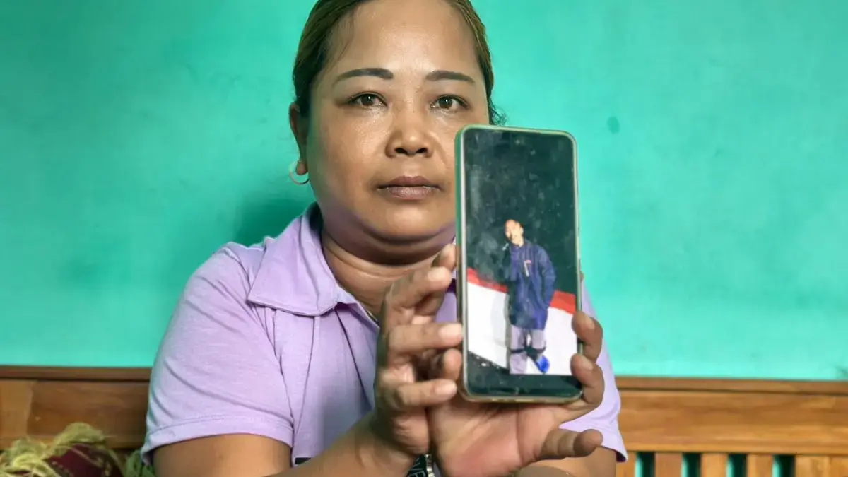 Eti Rohaeti (39 tahun) menunjukkan doto anaknya seorang ABK yang hilang di Selat Bali November 2025 lalu. (Cec