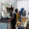 Seorang Penjahit Rumahan sedang menyelesaikan pesanan di kios jahitnya, menjelang Ramadhan, permintaan jasa ja