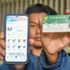 : Warga menunjukan aplikasi Mobile Jaminan Kesehatan Nasional (JKN) dan Kartu Indonesia Sehat